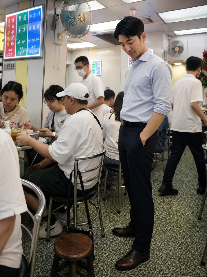 立信在澳洲牛奶公司狹窄走道旁看著已離開地面的手袋帶。